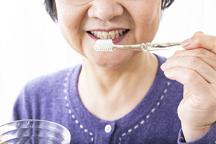 歯ブラシを持つ年配の女性